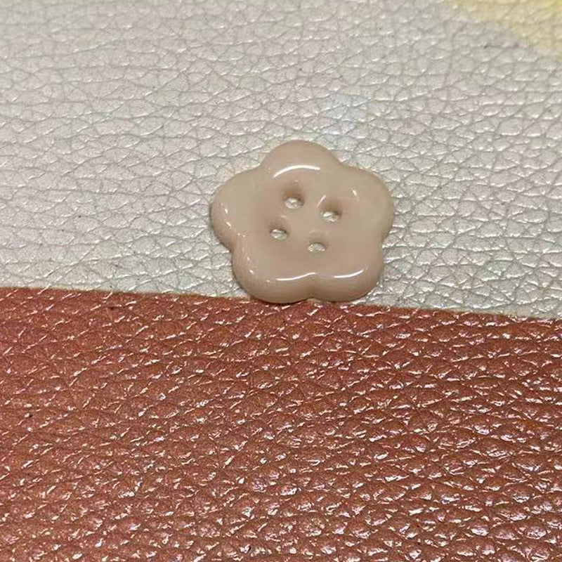 Beige flower-shaped ceramic clothing button, four holes