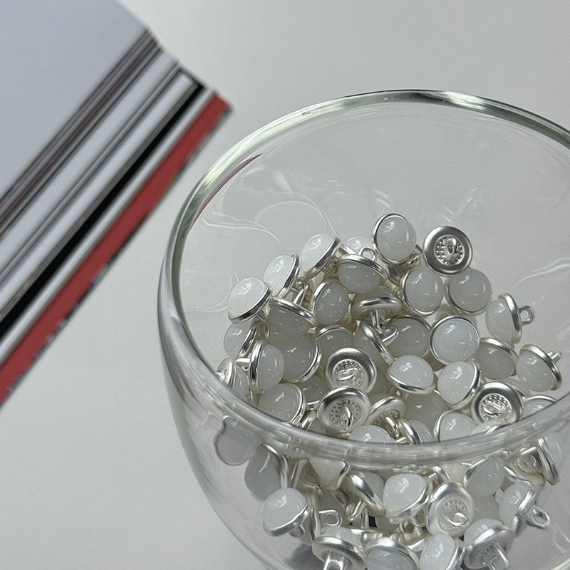 Jar filled with silver base jelly alloy buttons in light/white tones