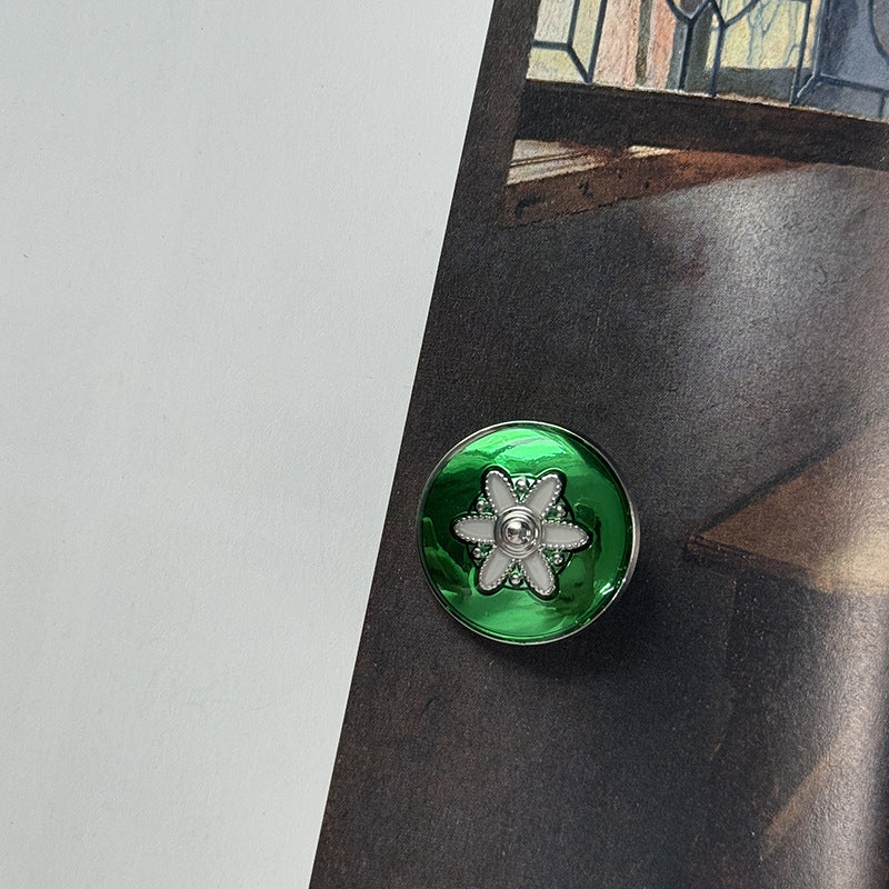 Green alloy button with gold flower motif and central metal shank