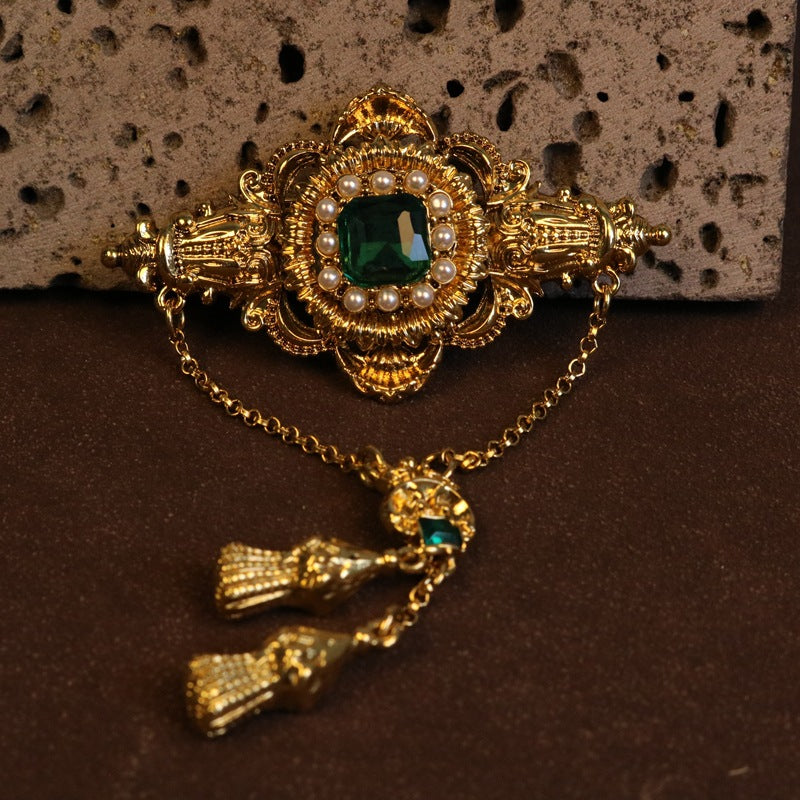 Green gem baroque brooch with pearl border and gold chain links with tassels