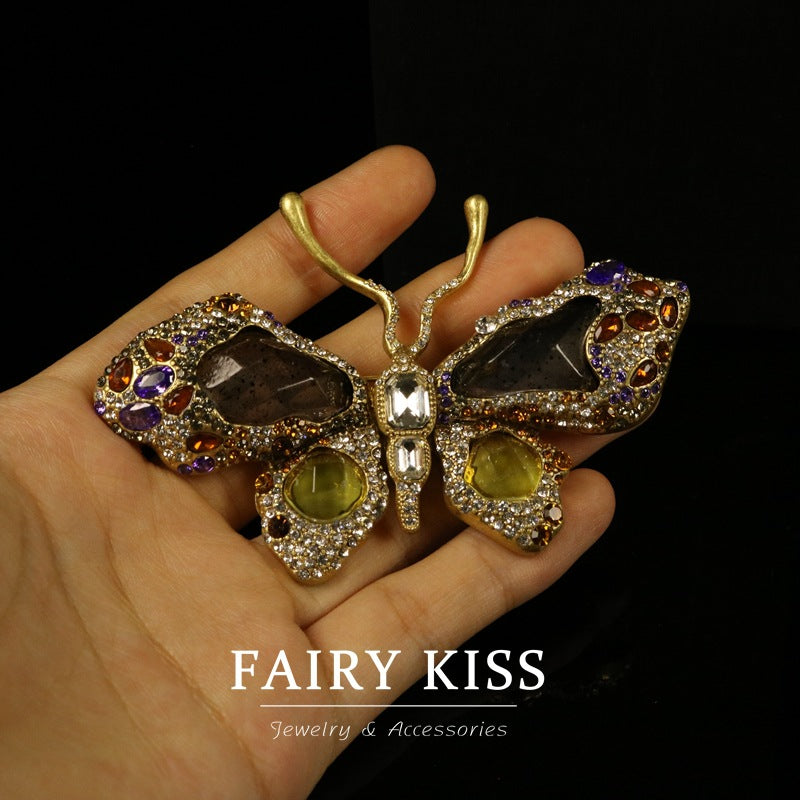 Butterfly brooch in gold-tone rhinestones with purple, amber, and green jeweled details