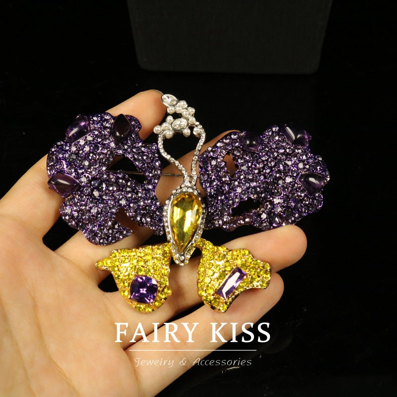 Purple butterfly brooch with yellow crystal drop center and small purple gem wings