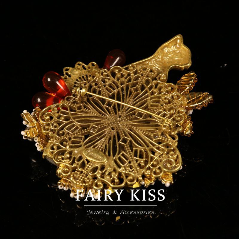 Gold filigree cat brooch with red bead accents and textured rhinestone mesh back pin