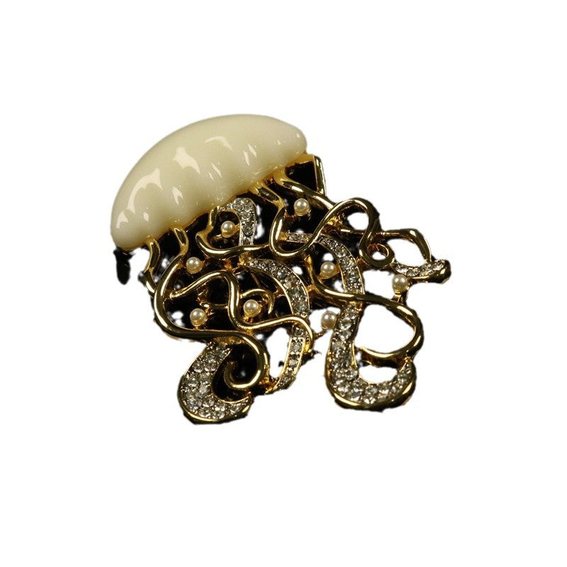 Handcrafted jellyfish brooch with gold filigree, pearl accents, and diamond-like stones