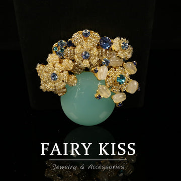 Vintage flower brooch, woven gold beadwork with blue stones and opalescent center