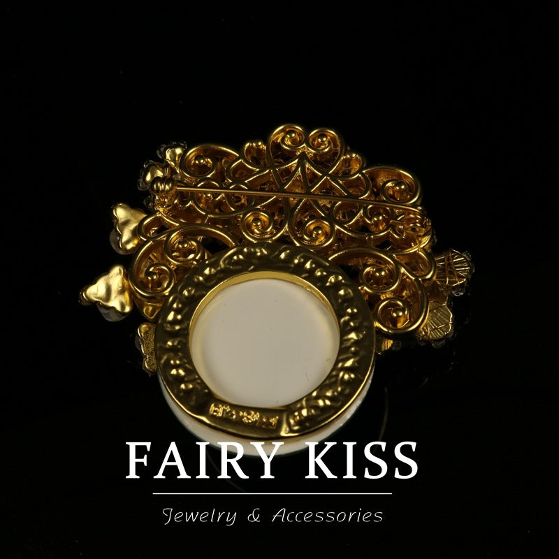 Ornate filigree brooch back with round cabochon-like white centerpiece