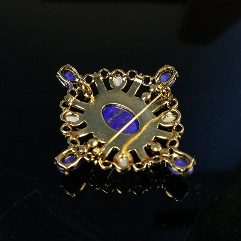Reverse view of oval lapis lazuli brooch setting with gold-tone filigree and pin