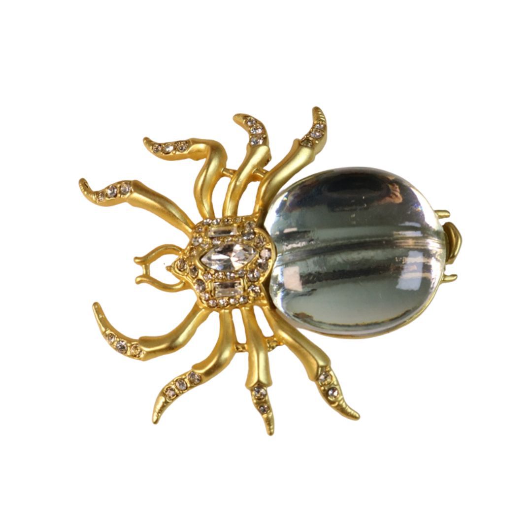 Gold-tone rhinestone spider brooch with mirrored oval body and raised legs