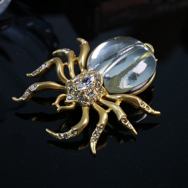 Rhinestone spider brooch, gold-tone legs, oval mirrored center with sparkle accents