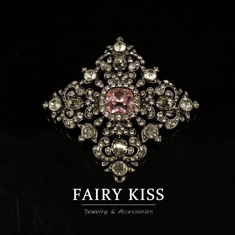 Geometric vintage brooch with rhinestones and a pink center crystal, gold-plated