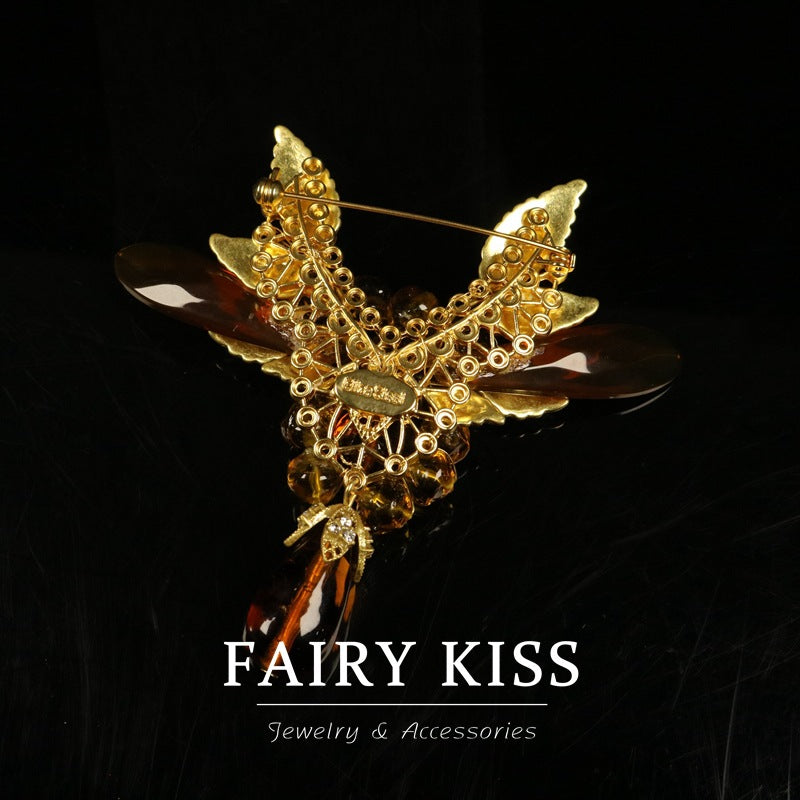 Amber beaded wing brooch with gold-tone cage details and curved pin