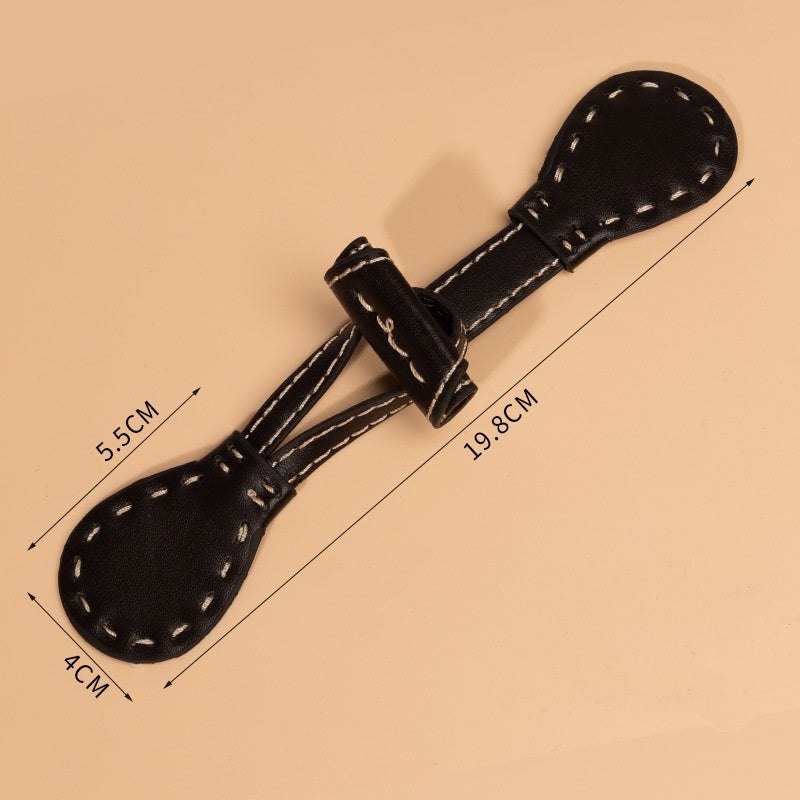 Ledertoggle schwarz, 19,8 cm lang; Knopf 5,5 cm; Breite 4 cm, Ösen am Riemen