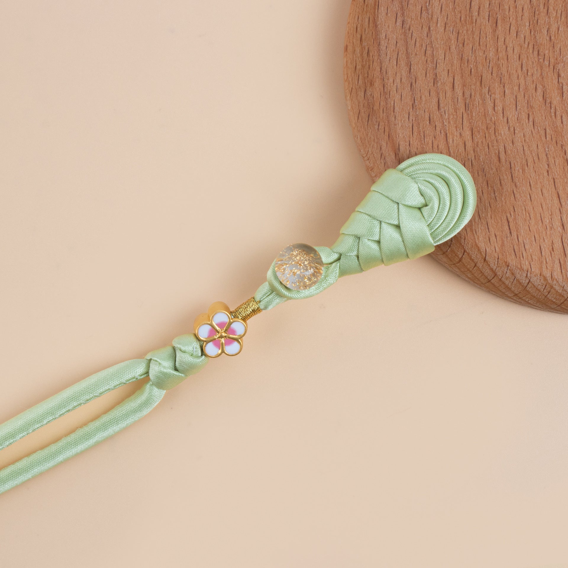 Light green braided frog button strand with gold flower charm and glitter bead