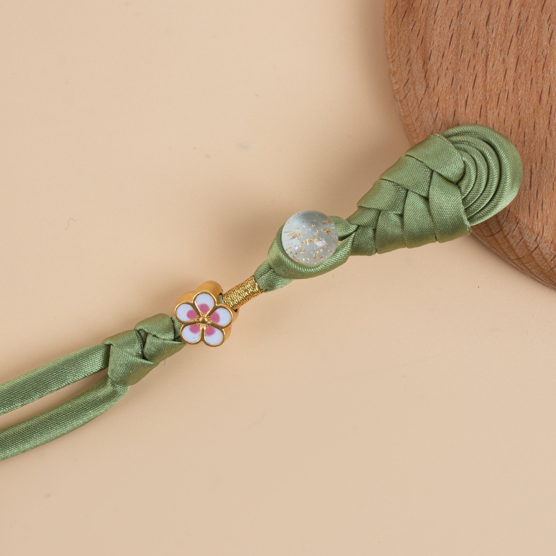 Green braided frog button strand with gold flower charm and glitter round bead