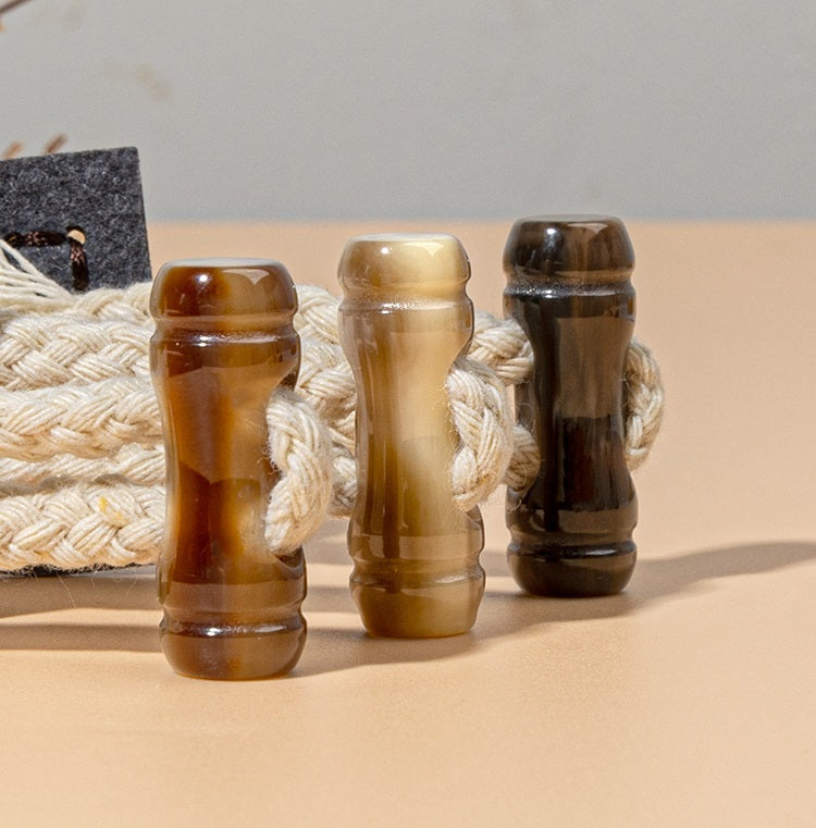 Braided cord with clear and dark ring pieces for leather sew-on toggles