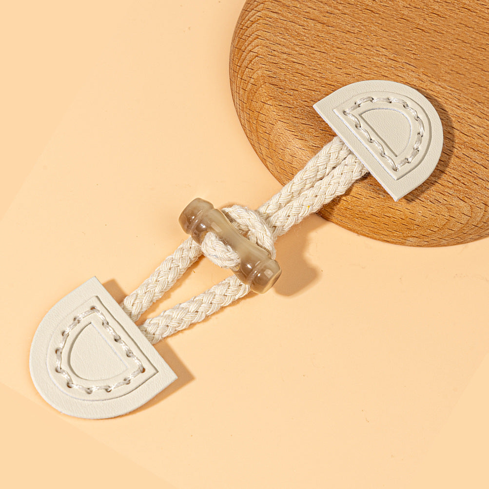 Beige leather sew-on toggle with white braided cord and clear ring fastener
