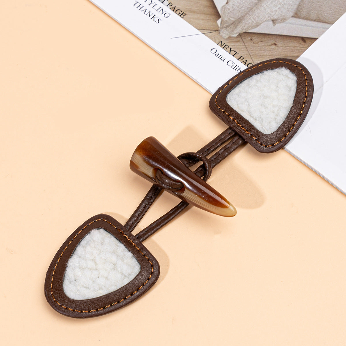 Brown leather sew-on toggle with resin horn button, textured white center panel