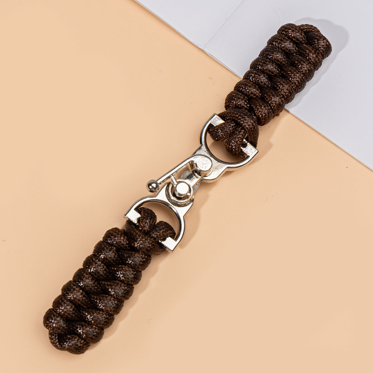 Dark coffee waxed-rope sew-on toggle button with metal buckle, close-up