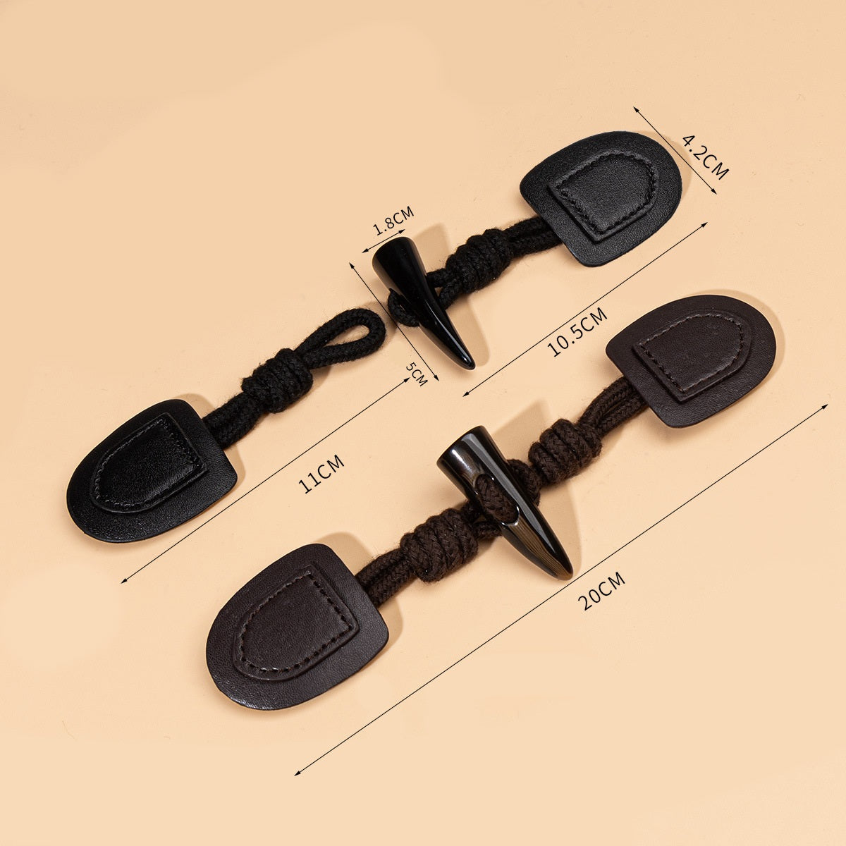 Black leather sew-on buttons with resin horn and cord, size marks show 20cm length