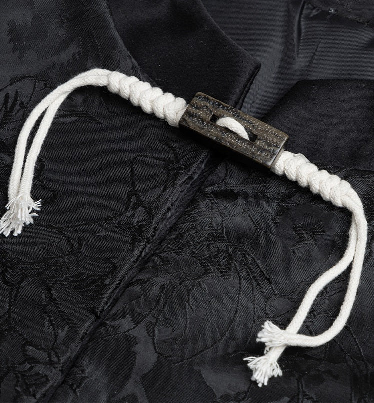 Sewn toggle button on fabric: rectangular resin bar with white-beige hemp cord loops