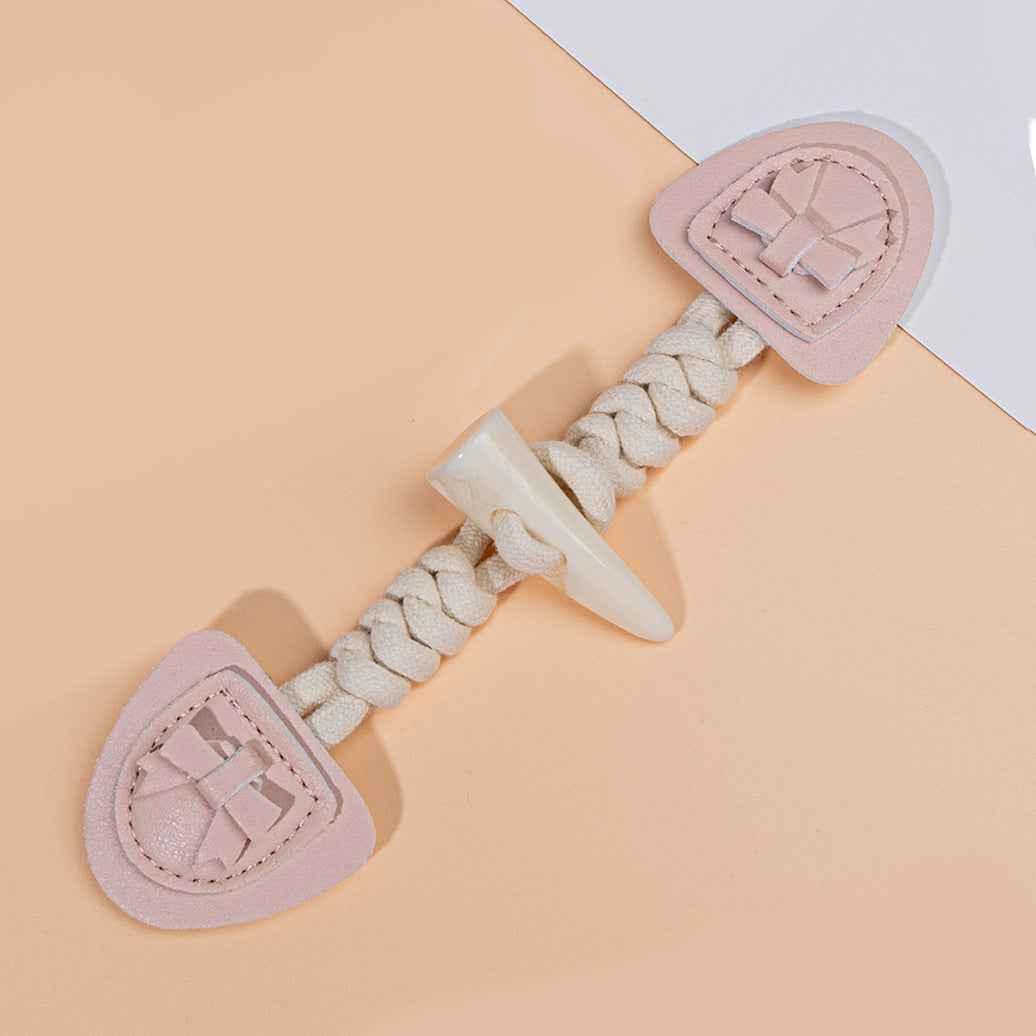 Pink leather buckle with braided cord loop and clear horn tip, heart-shaped base