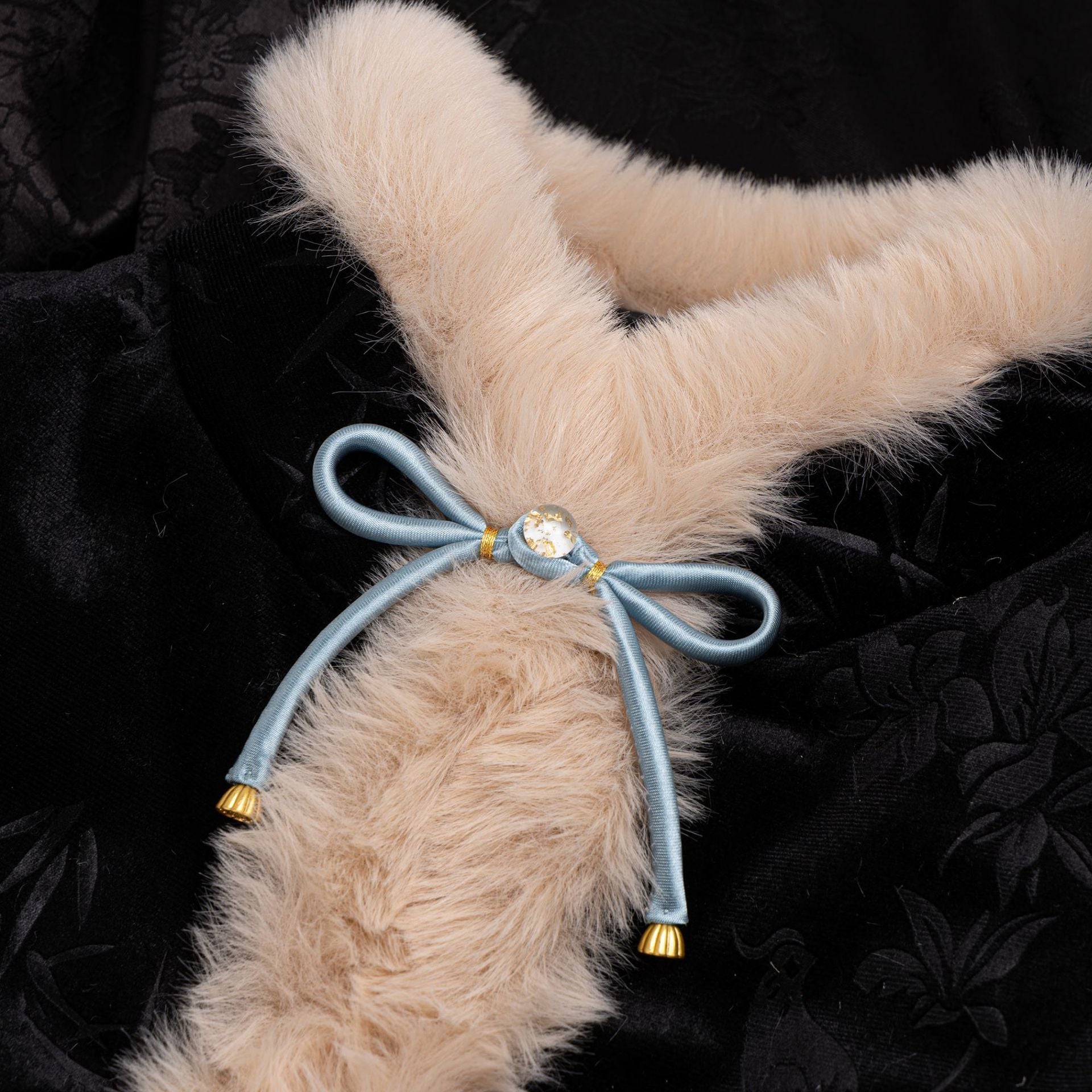 Satin bowknot button with light-blue ribbon, gold center and tassel ends