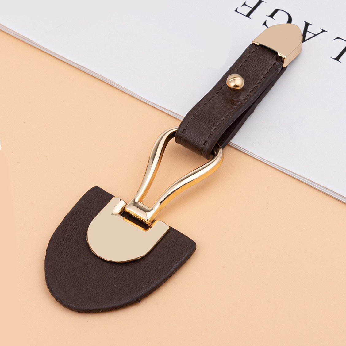 Dark brown leather sew-on toggle with gold metal buckle and rivet