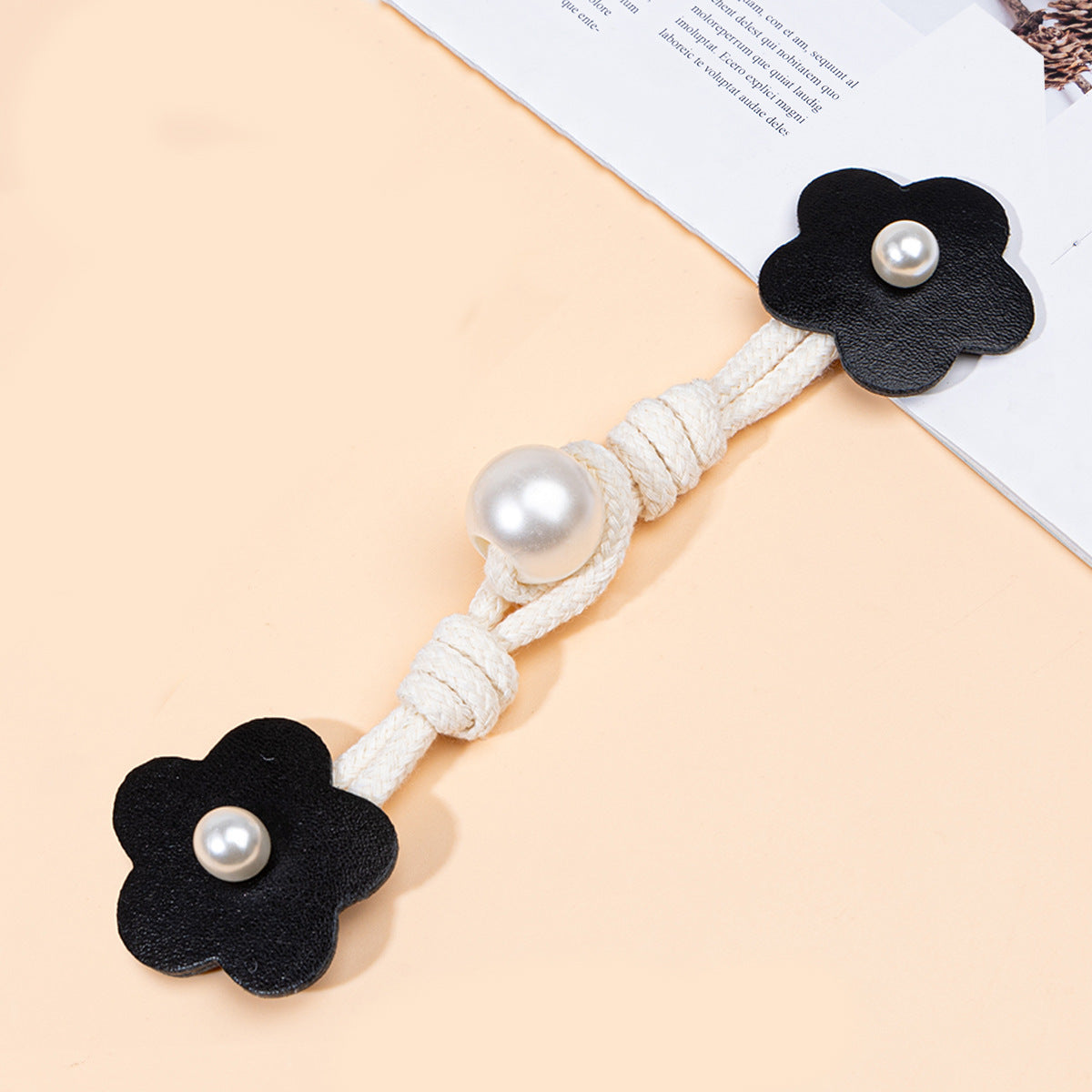 Schwarze Leder-Toggle mit Perlenknopf, Blumenform, an Kordel