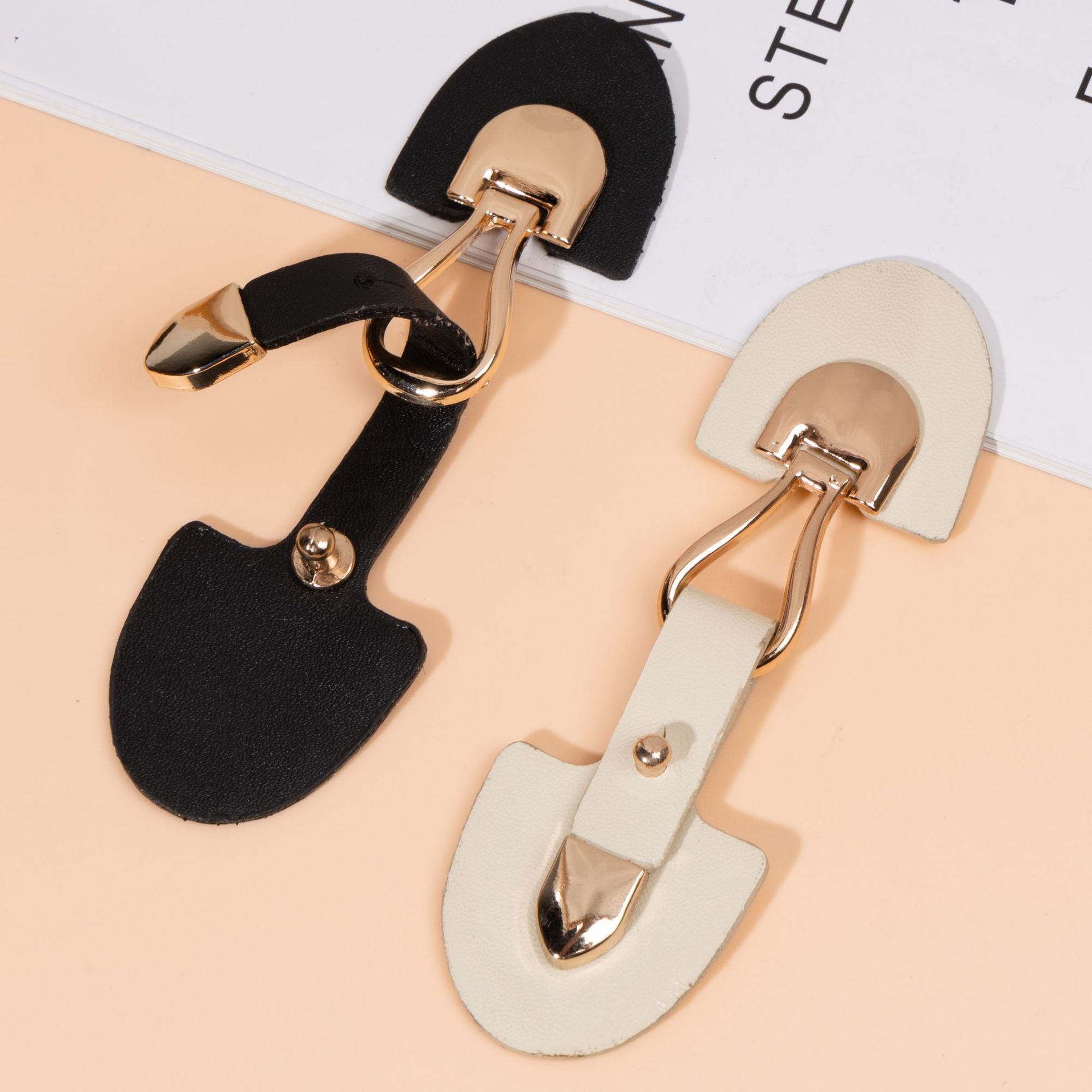 Beige and black leather sew-on toggles with metal buckle details (pair)