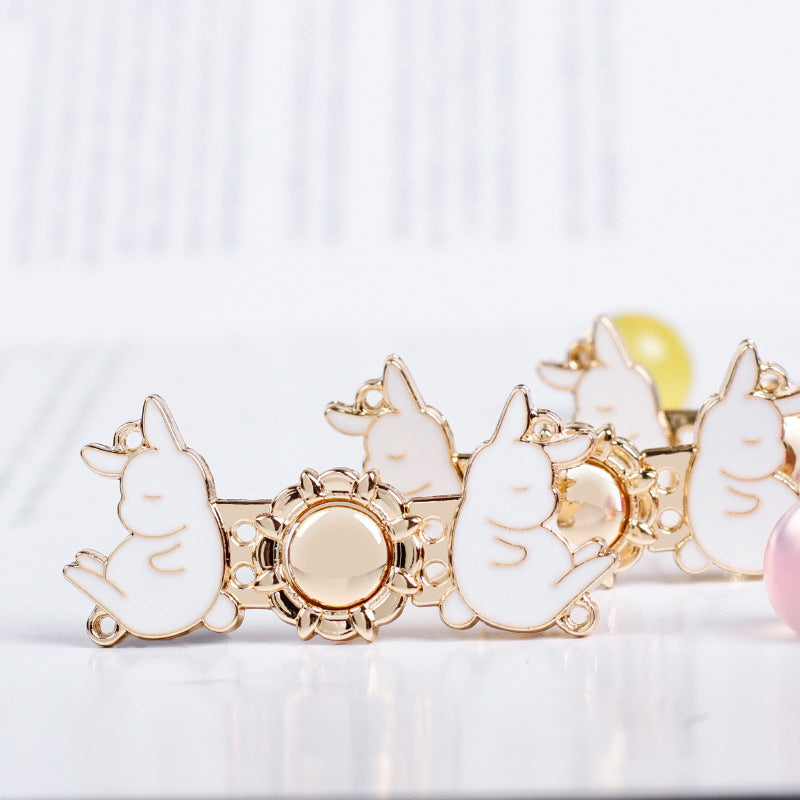 Light gold rabbit metal buttons with round center and white enamel faces, angled view