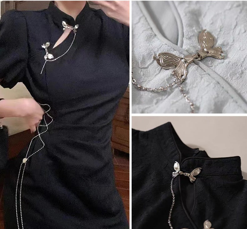 Butterfly hook decoration buttons on a black dress neckline, linked chain