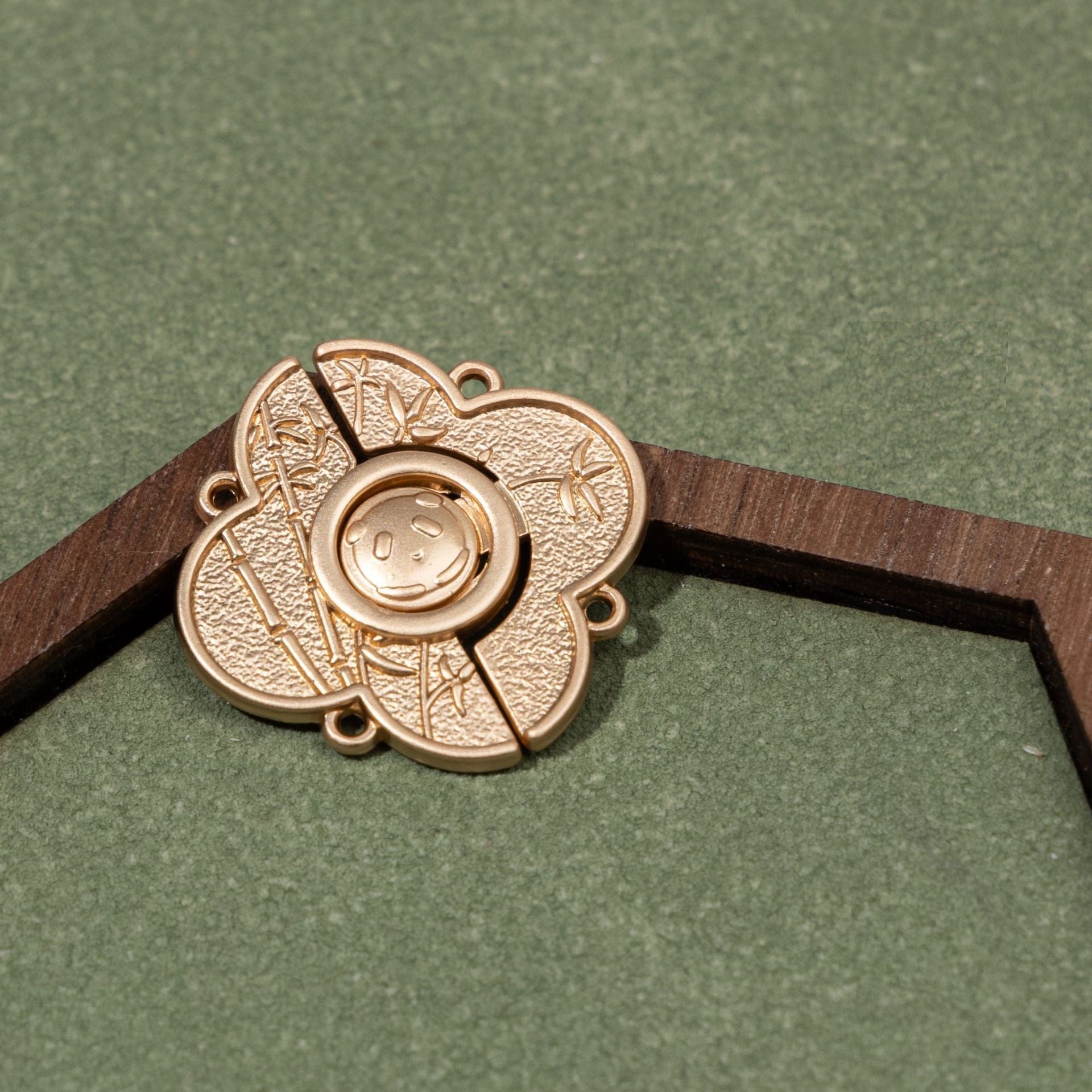 Panda metal button, light gold tone, leaf-pattern details, four-hole mounting