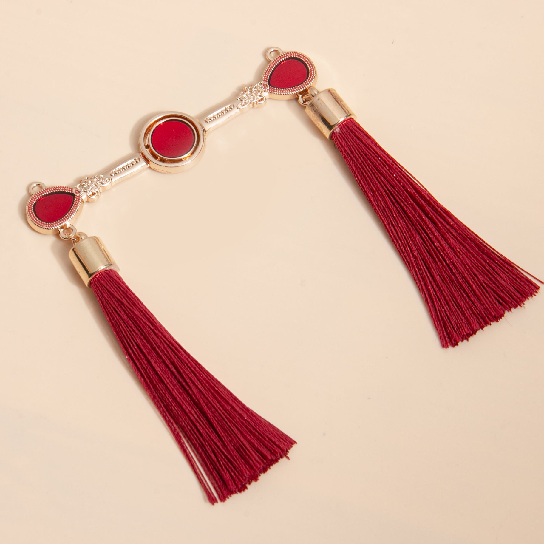 Gold-tone Chinese frog buttons with red tassels and round red enamel links