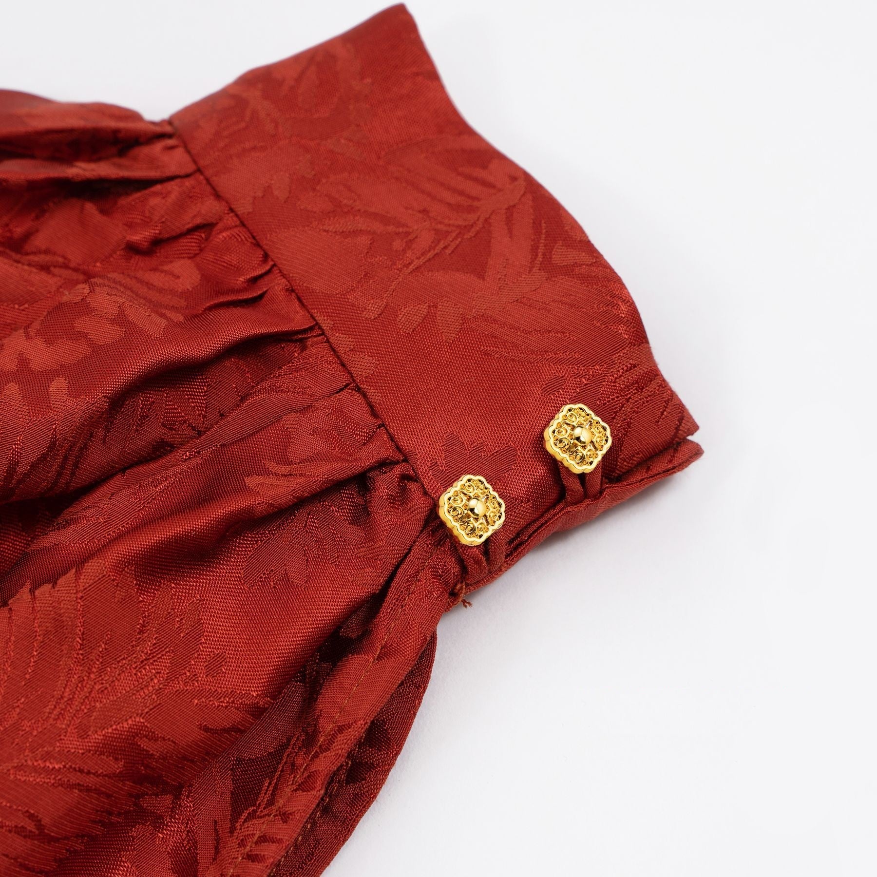 金色方形金属扣（带圈），用于红色服装门襟，纽扣外露2颗