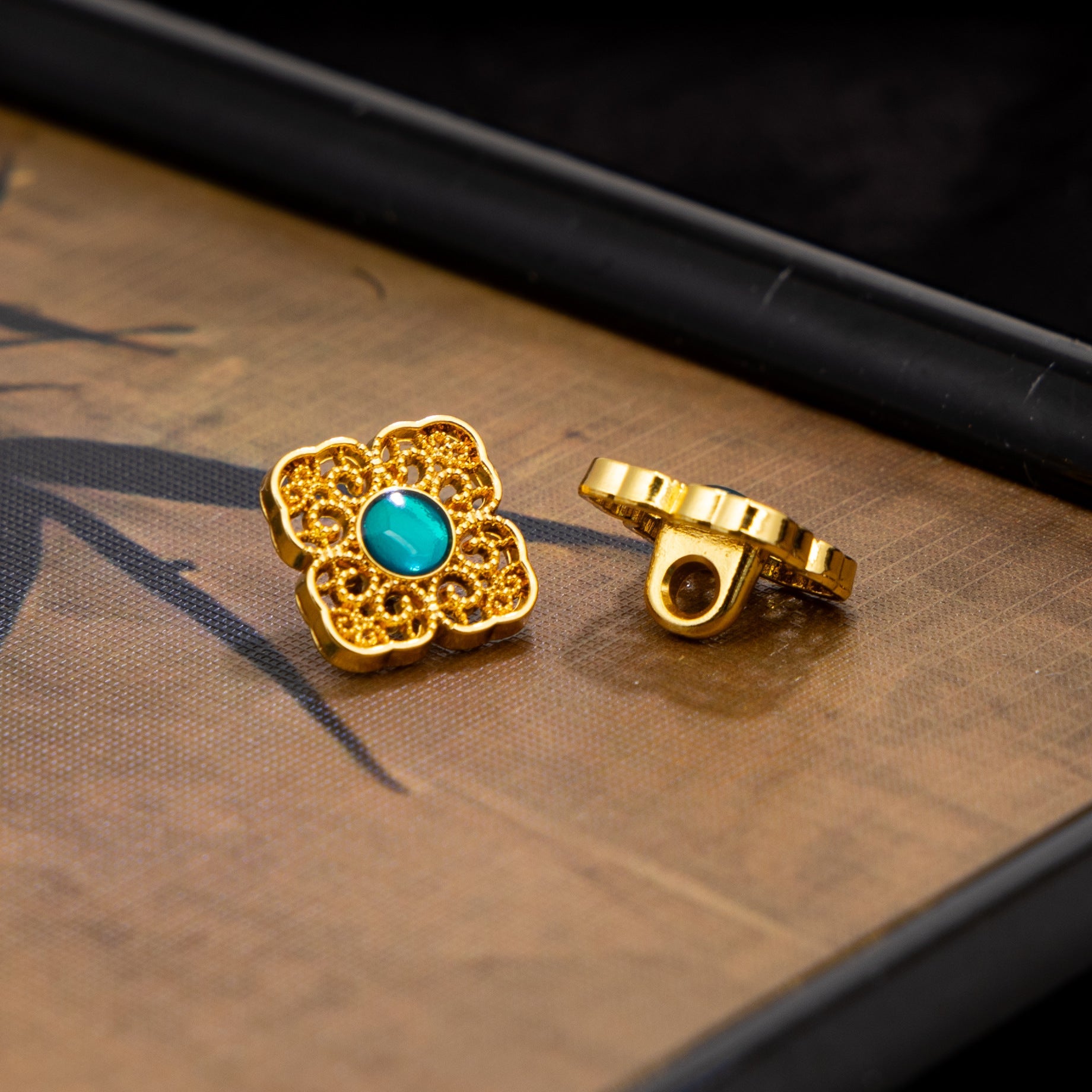 Gold square button with teal round center and matching metal back