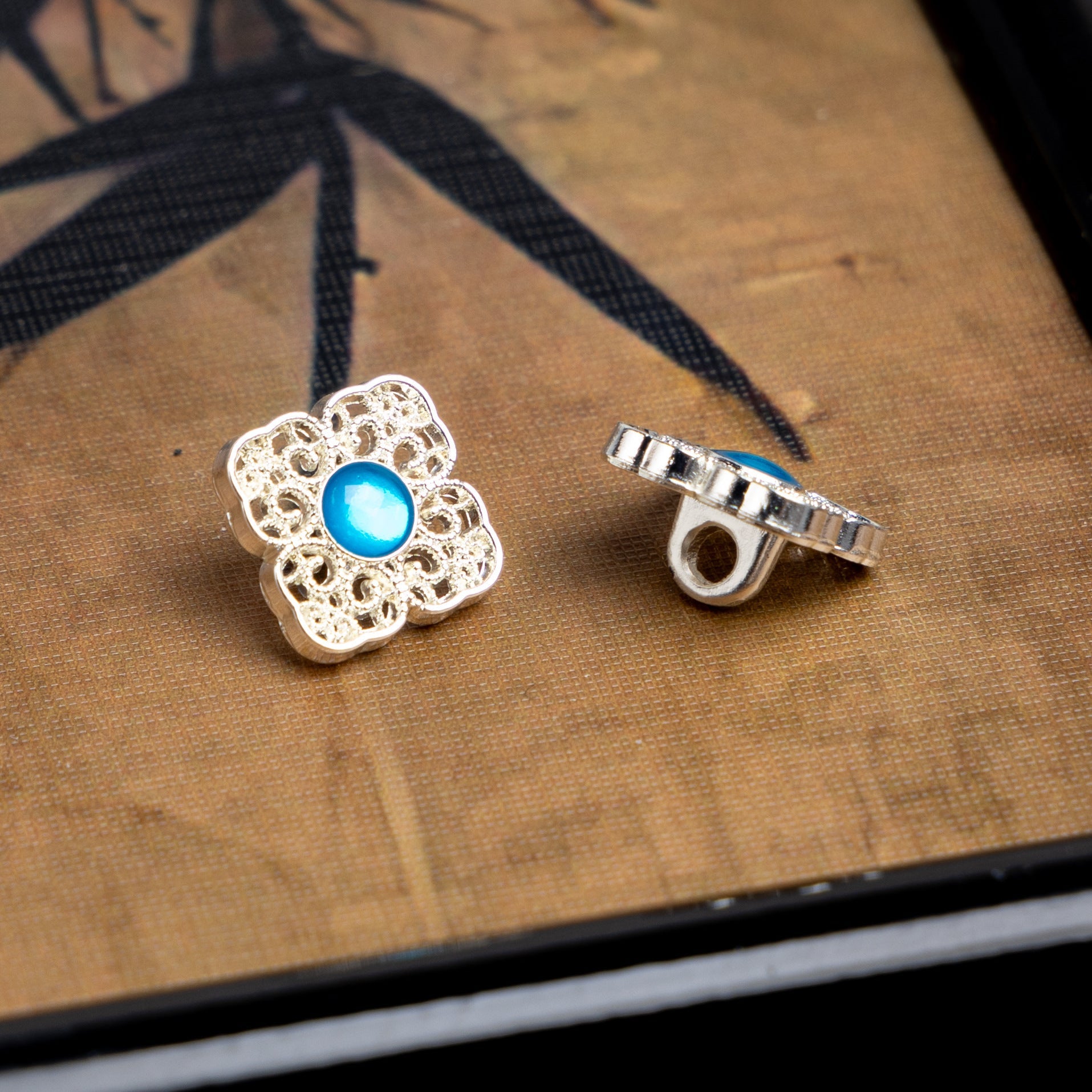 Silver square button with blue round center and metal back, Chinese-style filigree