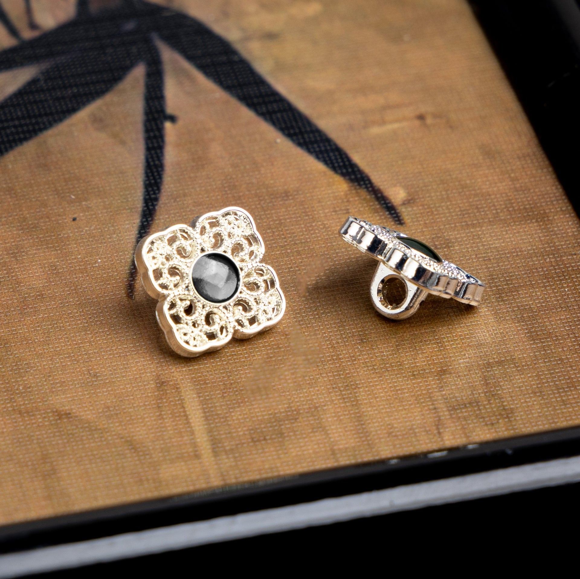 Silver square Chinese-style button with dark round center and matching metal back