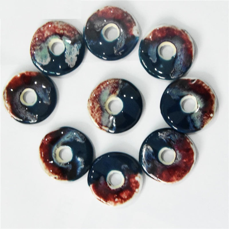 40mm round ceramic ornament pendant buttons, red-tinged rim over dark blue base, center hole.