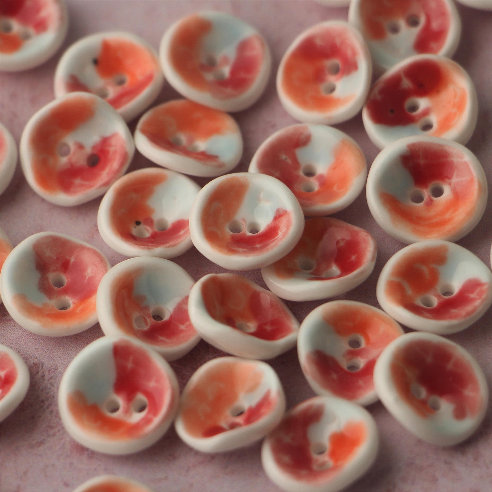 Keramikknöpfe 2 Löcher, handbemalt: creme mit rot-orangenen Tierchen-ähnlichen Mustern