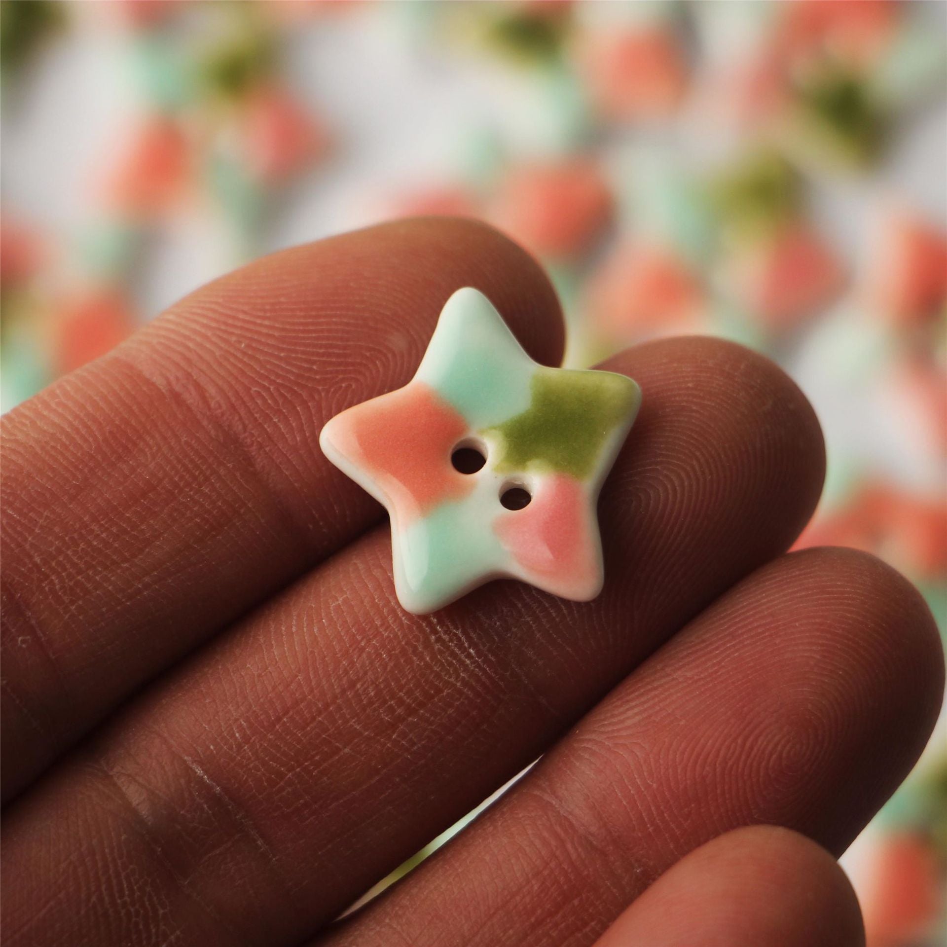 Aqua ceramic five-point star button with pink and olive accents, two holes