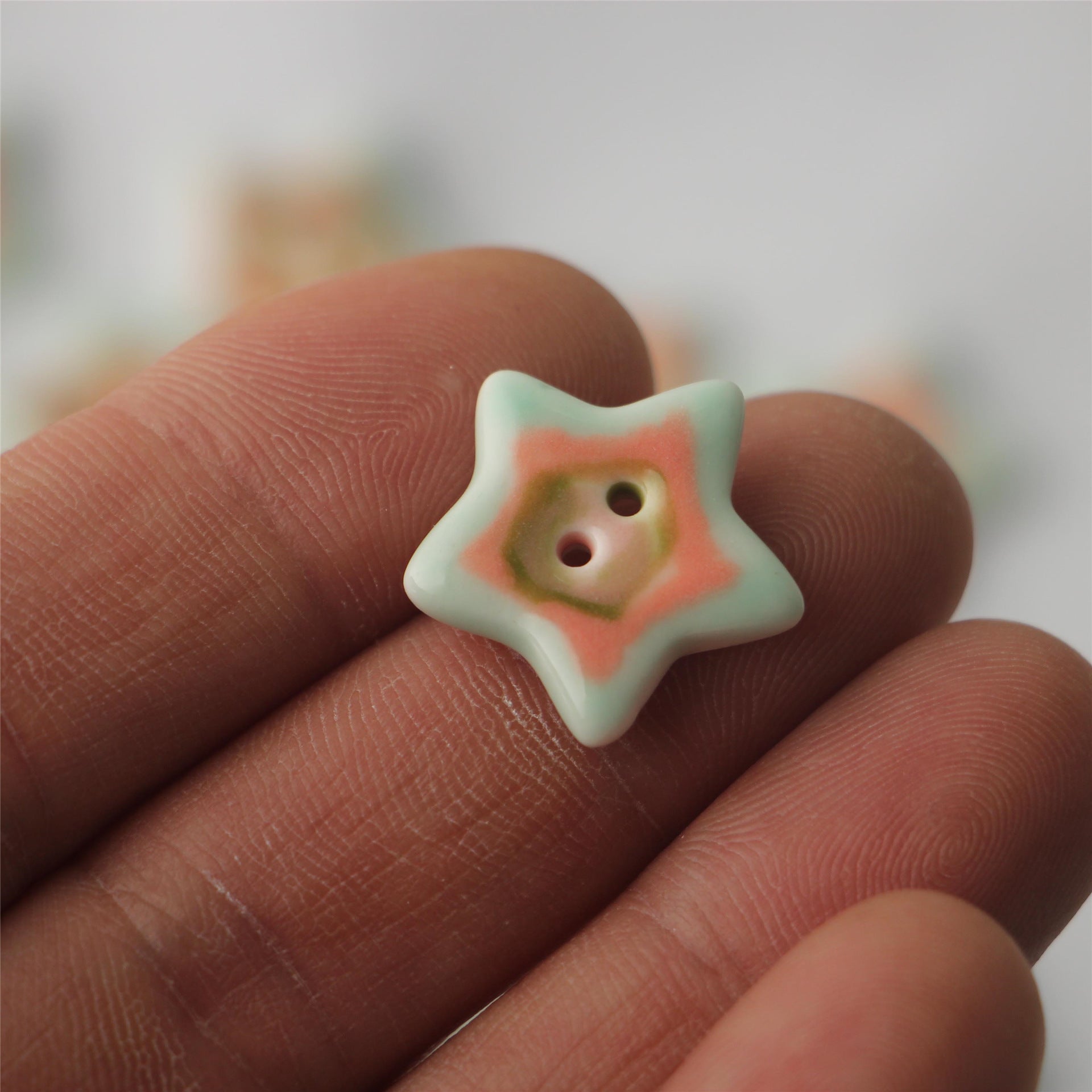 Mint and coral ceramic five-point star sewing button, two holes