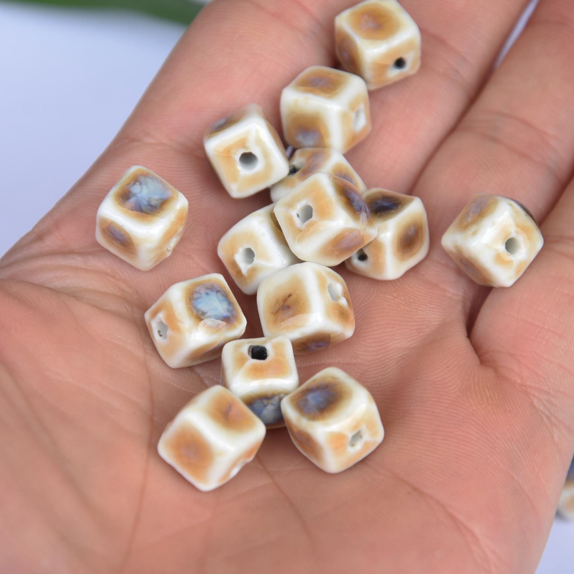 Handful of 10mm square ceramic beads, cream with blue-brown prairie scene, drilled holes