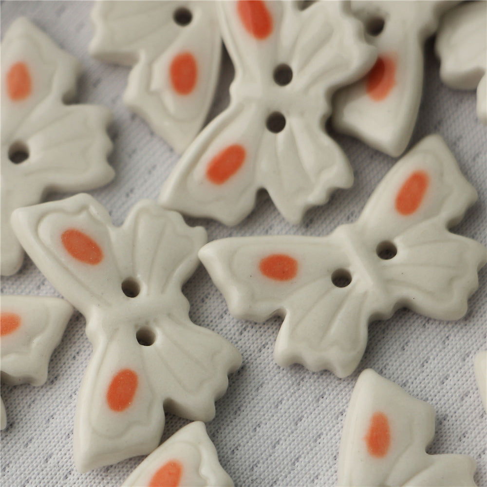 White ceramic butterfly buttons, 2-hole, orange oval accents