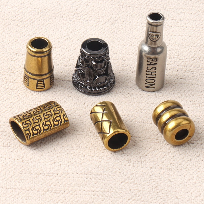 Mixed finish cord end lock stoppers: gold, black, and silver with decorative detailing