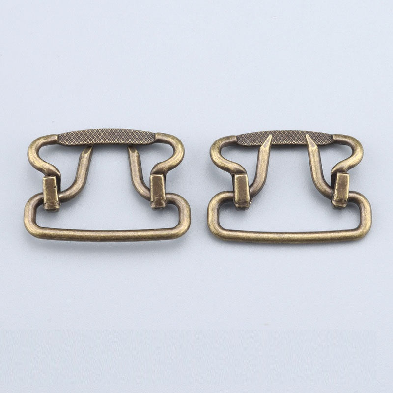 Two 28mm plated buckles in antique gold, one with textured top bar and two clips