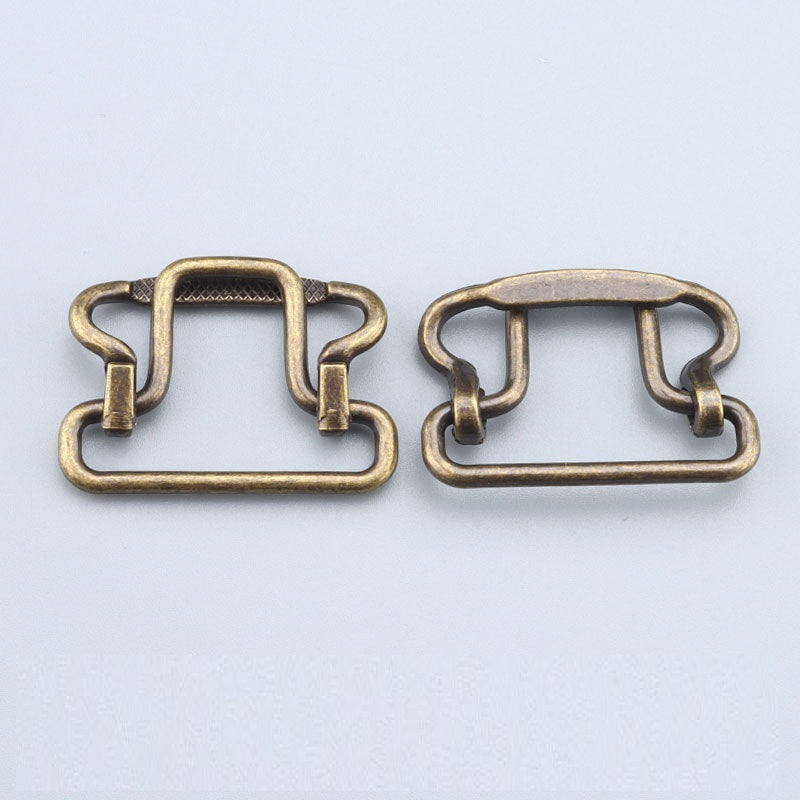 Two antique-gold 28mm buckle clasps; left has textured top bar, both with two clips
