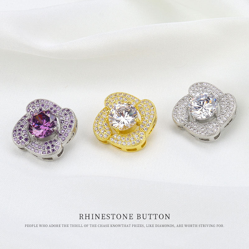 Three rhinestone buttons: purple, gold, and silver, each with round center stone and metal shank