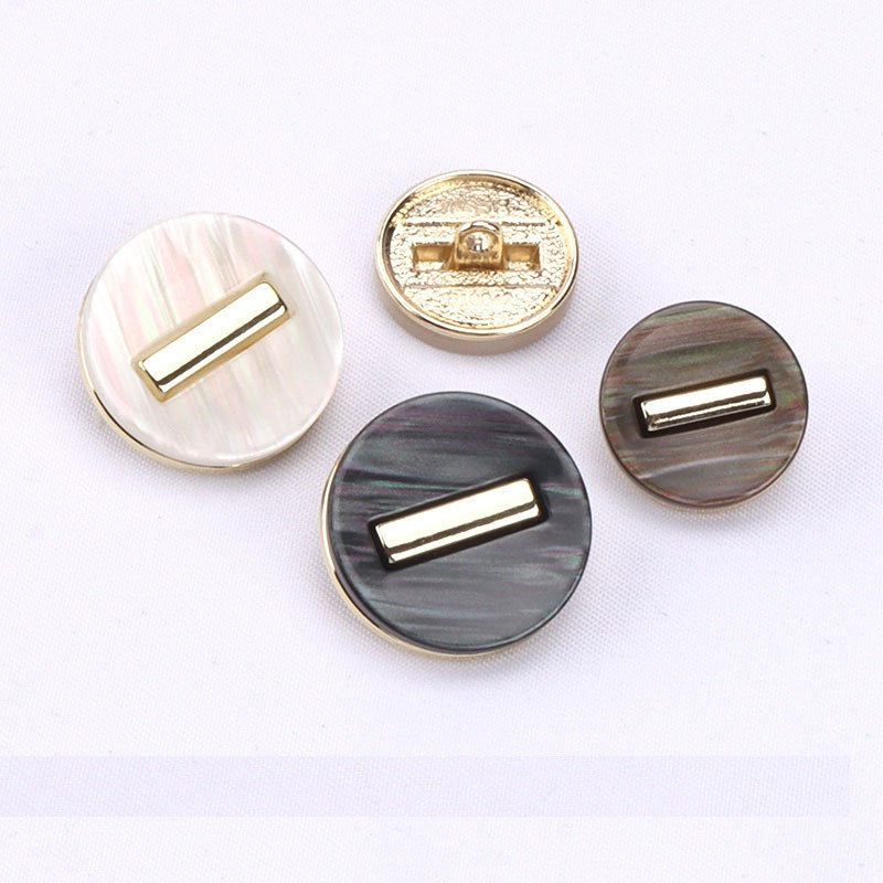 Assorted round resin shank buttons in white, black, and brown with gold-tone frames