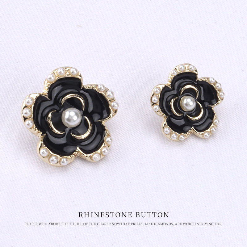 Black floral button set with gold trim and pearl-like borders, front view of two