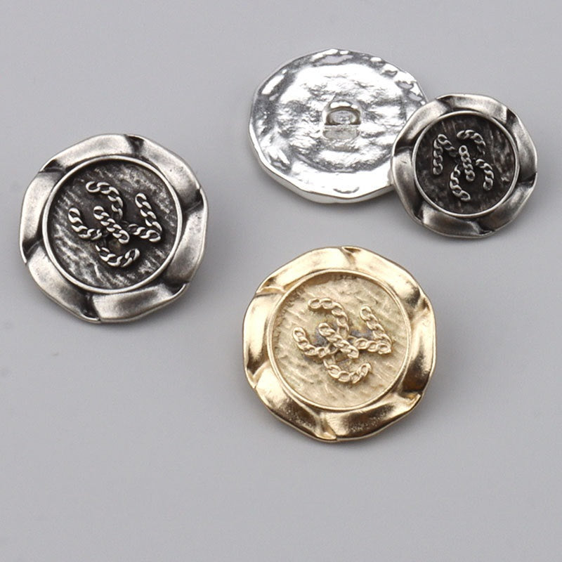 Metal buttons with ornate engraved fronts—silver, dark silver, and gold